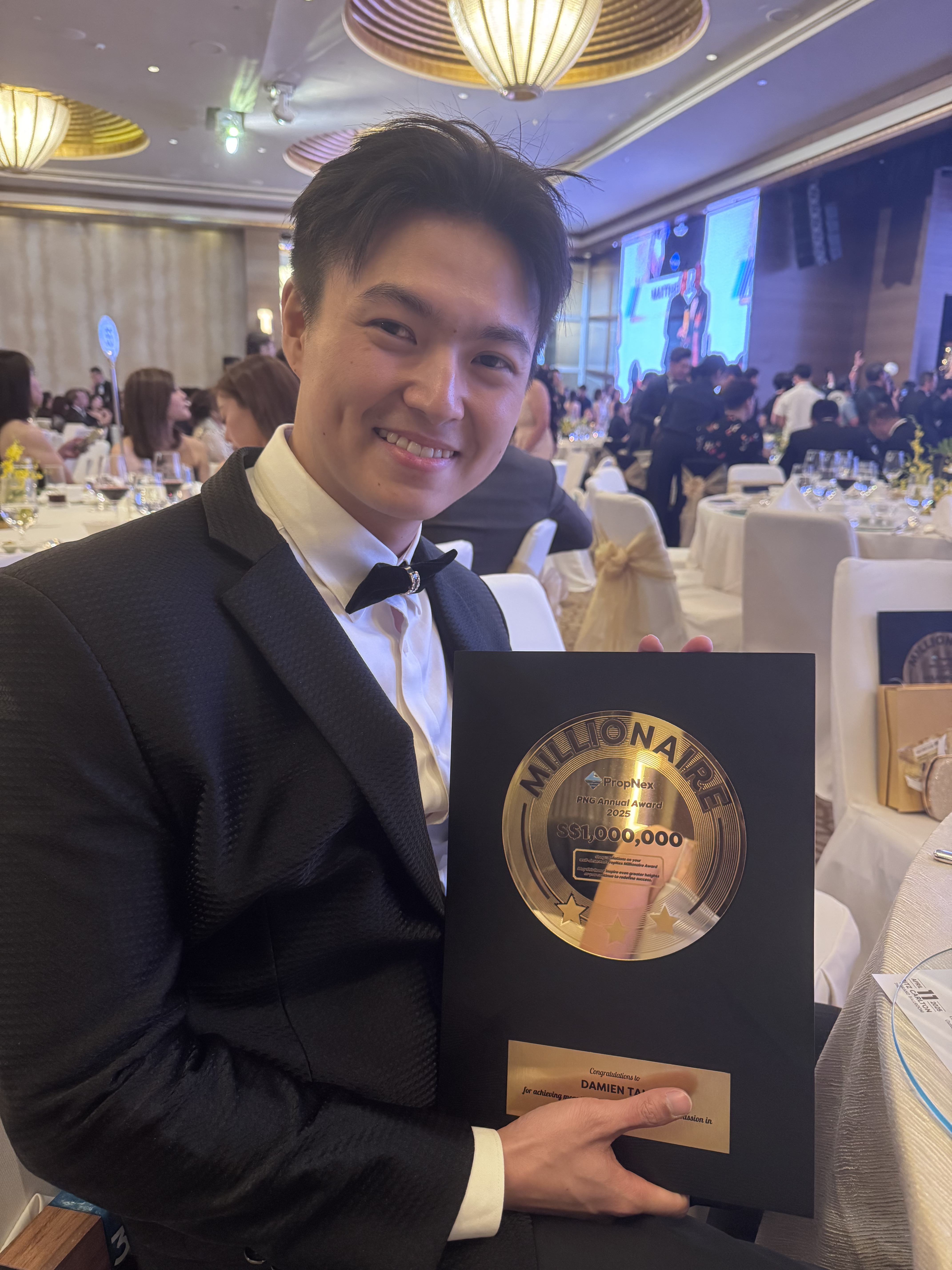 Damien Tan holding the PropNex Millionaire Award