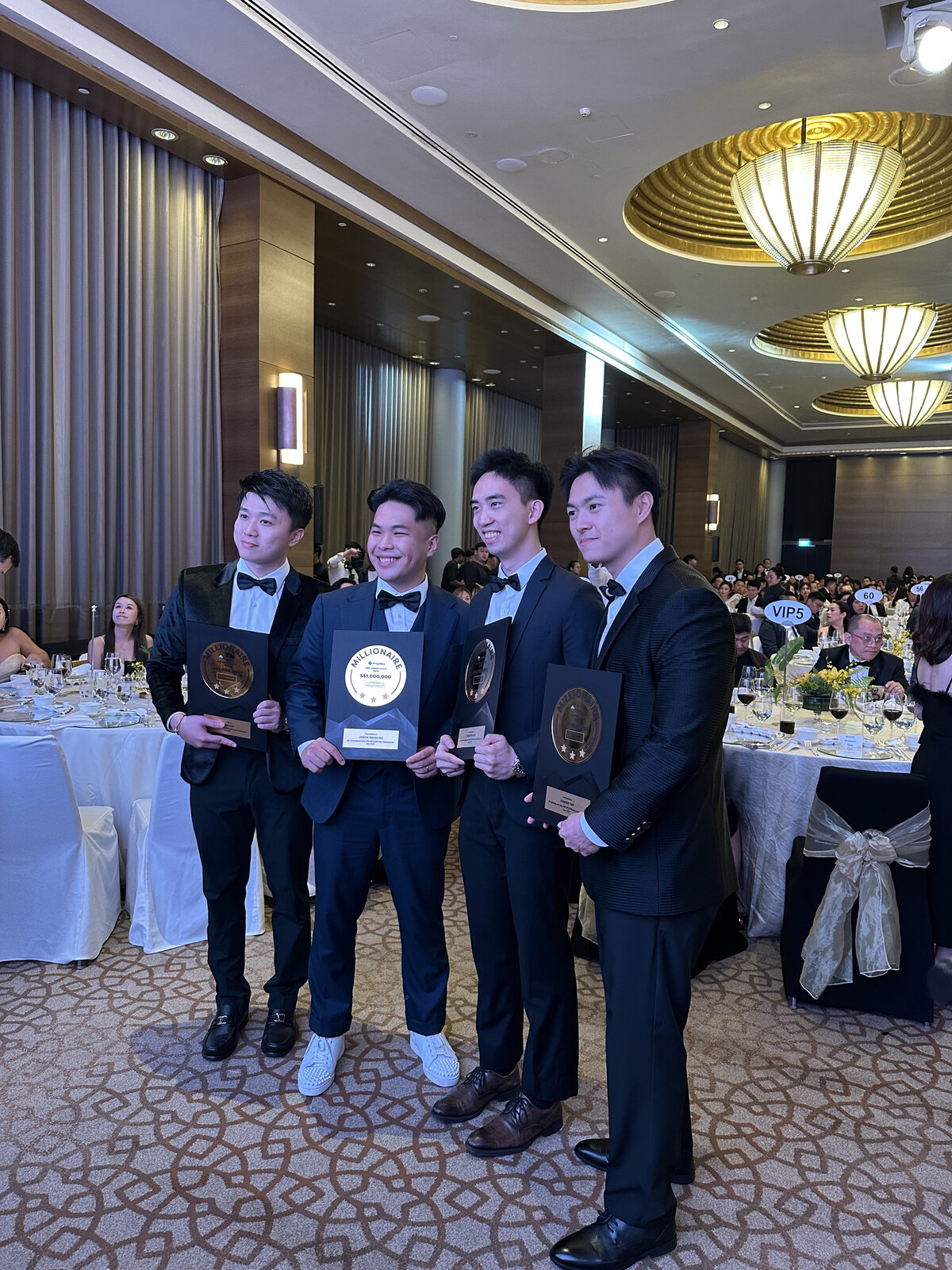 Damien Tan and the JNA team holding PropNex Millionaire awards
